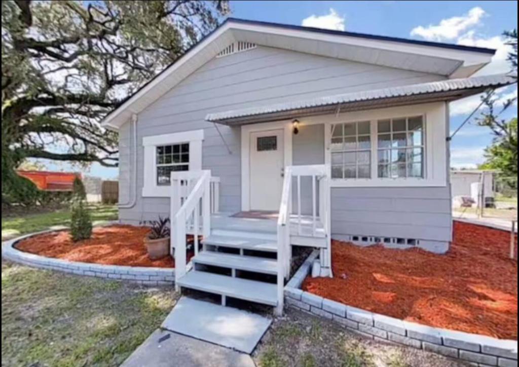 a small house with a white door and stairs at Central Tampa Hot Spot! in Tampa