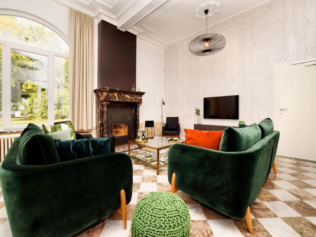 sala de estar con 2 sillas verdes y chimenea en Holiday home in Spa with bubble bath, en Spa