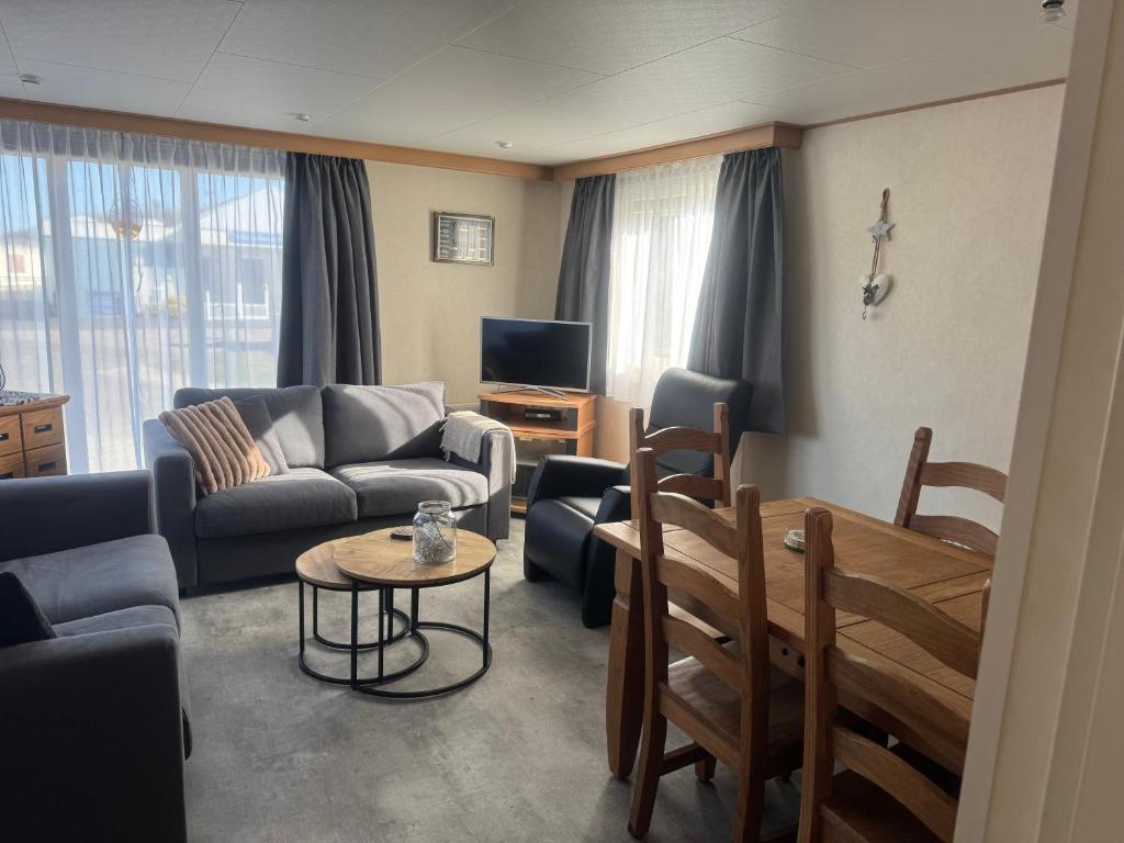 a living room with a couch and a table at Chalet op Ameland voor 5 personen in Buren