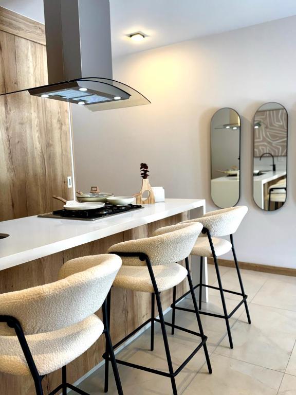 a kitchen with a counter with stools and mirrors at Loft Americana Chapultepec Alberca Wifi AC in Guadalajara