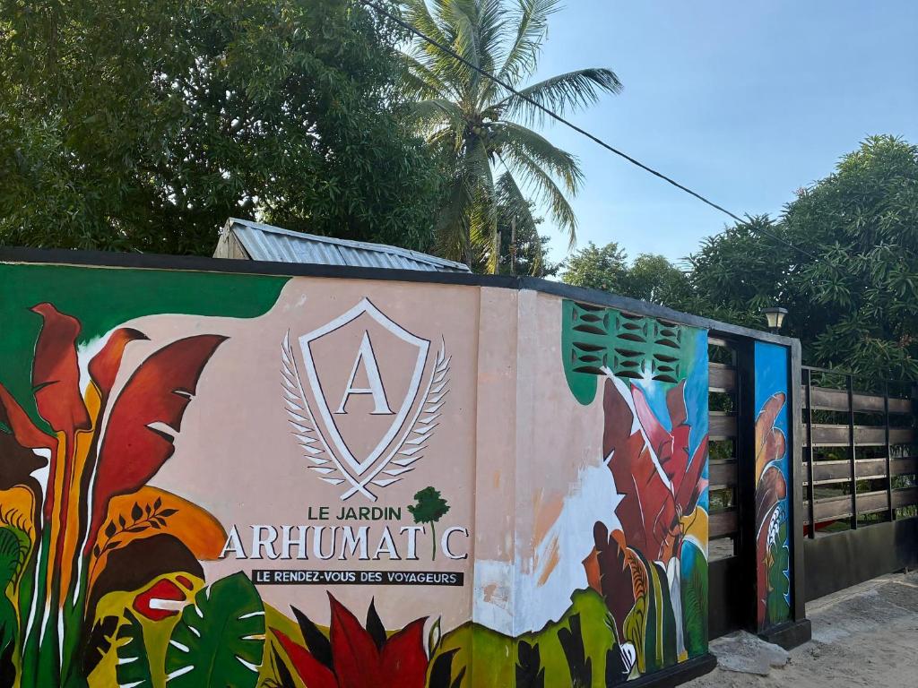 a sign on a wall with a painting on it at Le Jardin Arhumatic Sambava in Sambava