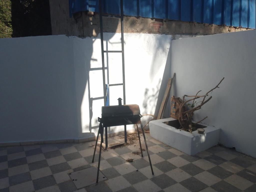 a chair sitting in front of a window with a ladder at Christiana 1 in Midoun