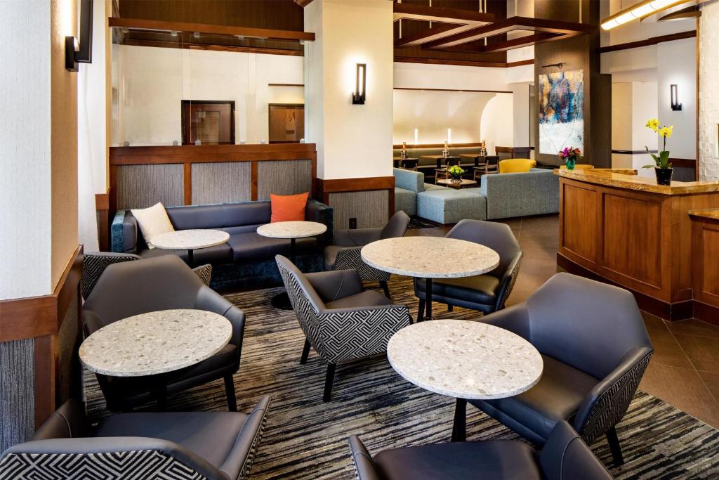 a lobby with tables and chairs and a waiting room at Hyatt Place Dallas Park Central in Dallas