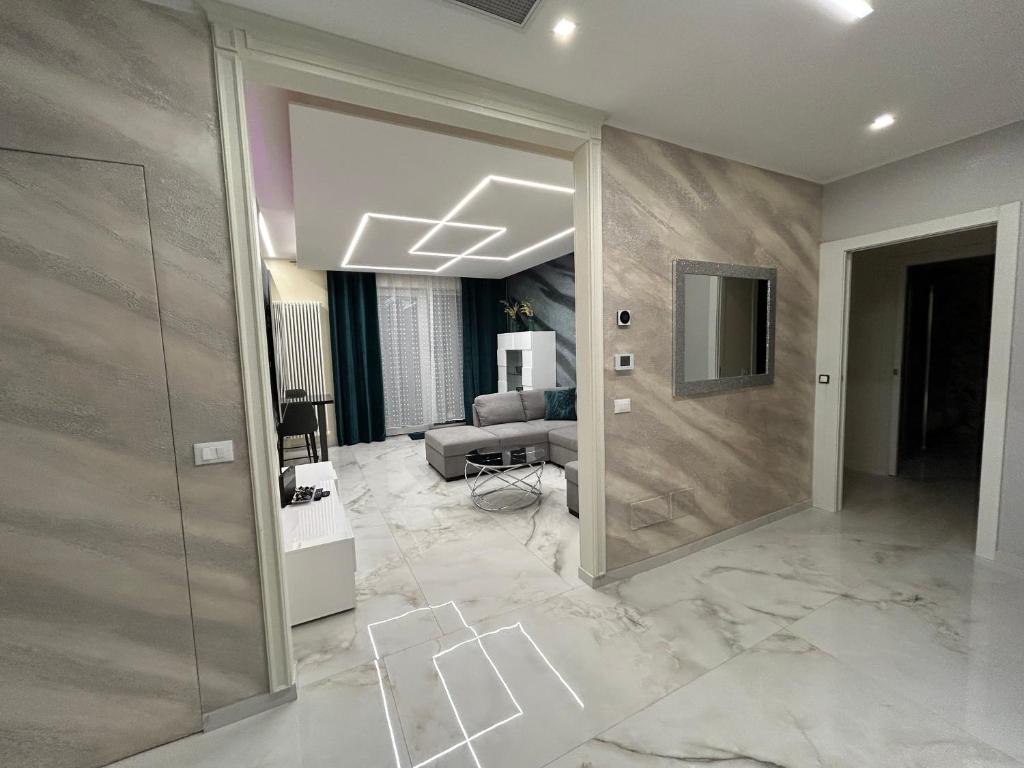 een woonkamer met marmeren vloer en een grote deuropening bij La Casa di MBAPE in Meda