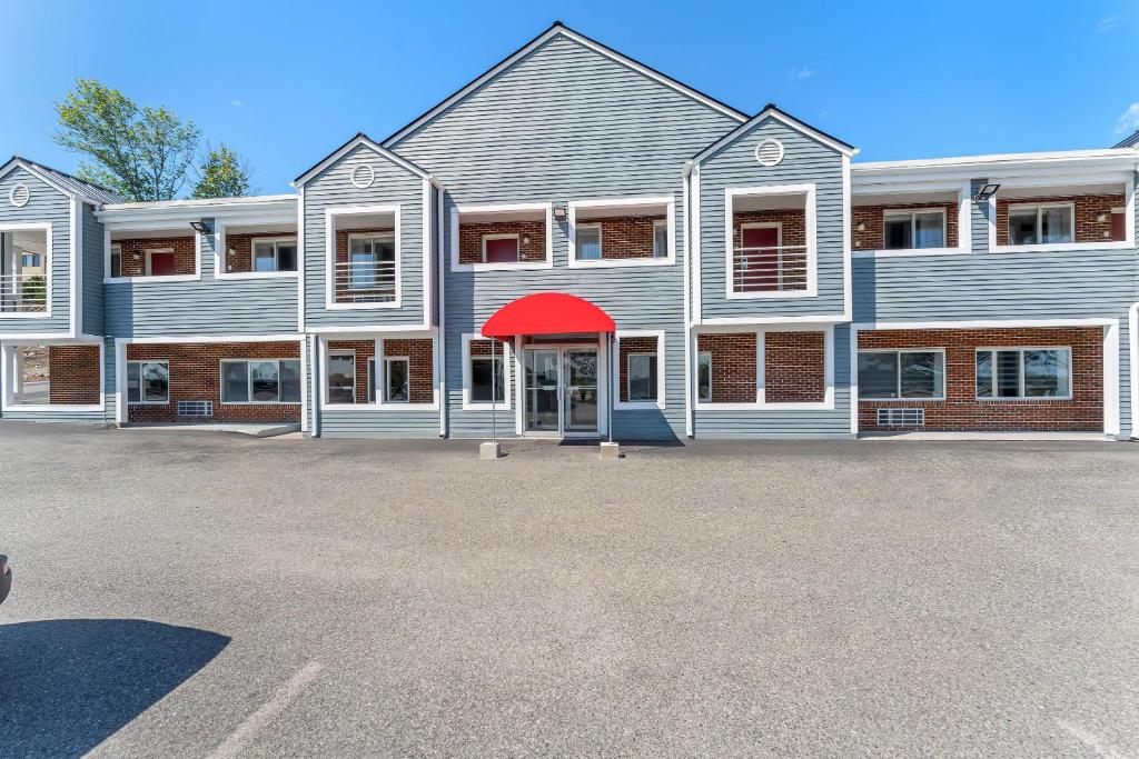 a large building with a red awning in a parking lot at Econo Lodge Cranston - Providence in Cranston