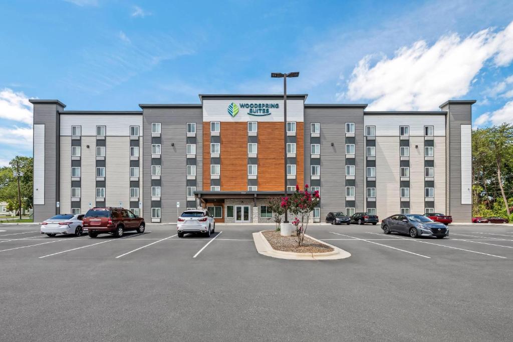 a large building with cars parked in a parking lot at WoodSpring Suites Winston-Salem near Hanes Mall in Winston-Salem