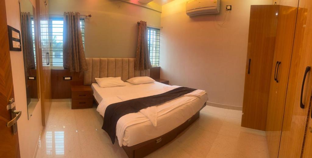a small bedroom with a bed and a window at MSK Homestay Service Apartments in Hubli