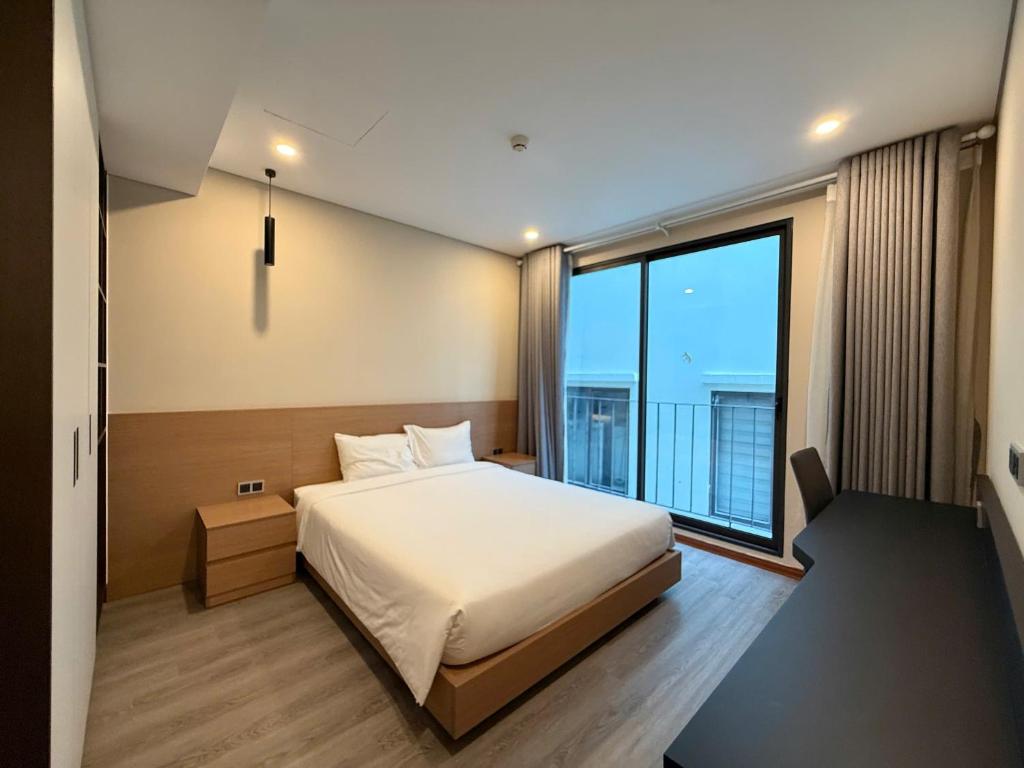 a bedroom with a bed and a large window at Regal Residences Tay Ho in Kon Rung (1)