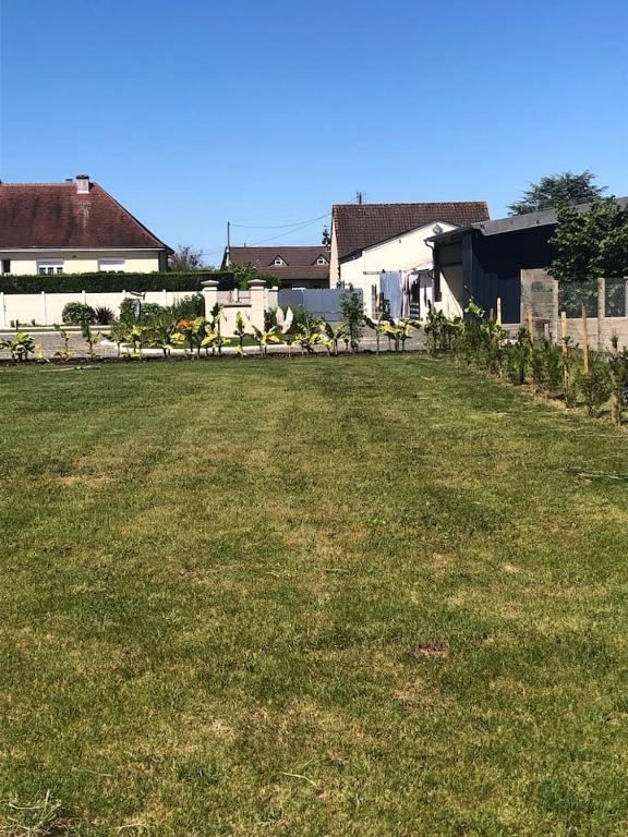 a large field of grass with houses in the background at House, lot, secure private parking in Issoudun