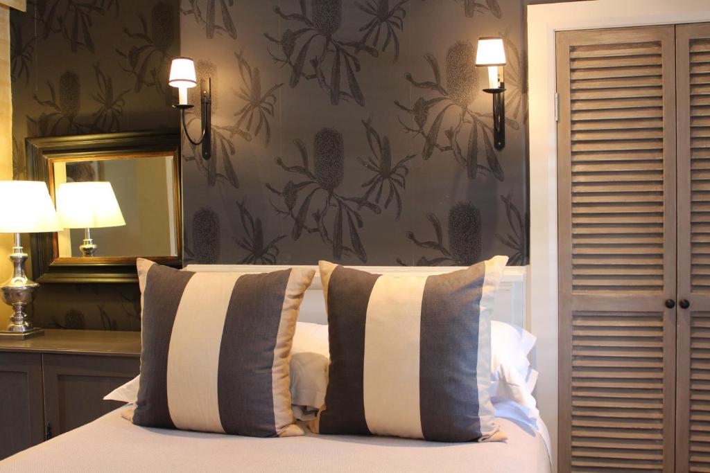a bedroom with a bed with two pillows and a mirror at Inn Scone in Scone