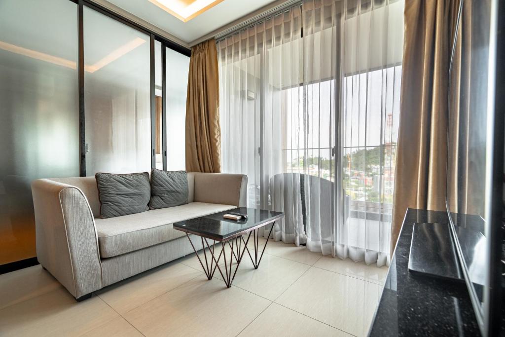 un salon avec un canapé et une table dans l'établissement Two Bedrooms Seaview Apartment Surin Bangtao Area 4407, à Ban Lum Fuang