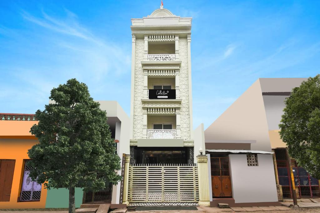 a tall white building with a tree in front of it at Collection O Paschim Dwar Near Jagannath Temple Formerly Hotel Subhadarshan in Puri