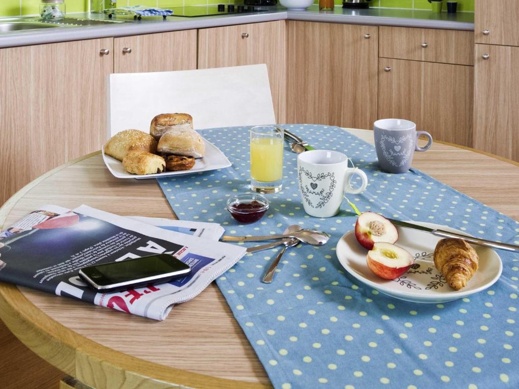 une table avec deux assiettes de nourriture et de boissons dessus dans l'établissement Aparthotel Adagio Paris Vincennes, à Vincennes