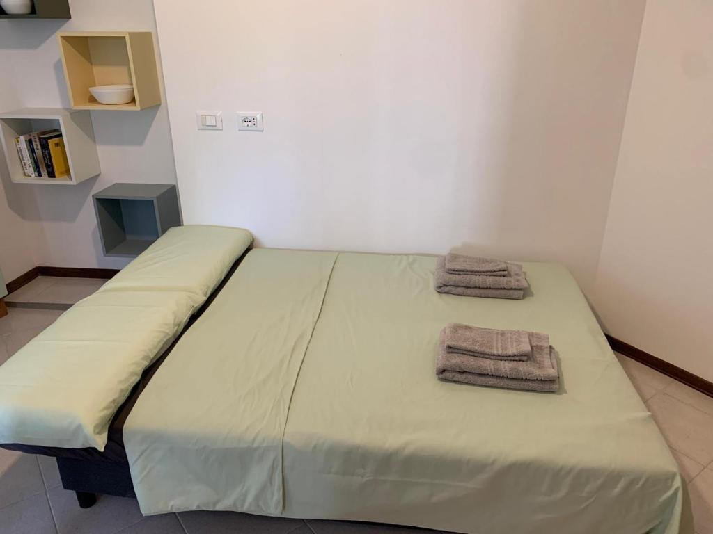 Una cama en una habitación con dos toallas encima. en ElenaM, en Udine