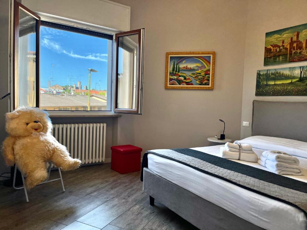 a teddy bear sitting on a chair in a bedroom at Art&Castle View 5 min from Sigurtà Park in Valeggio sul Mincio
