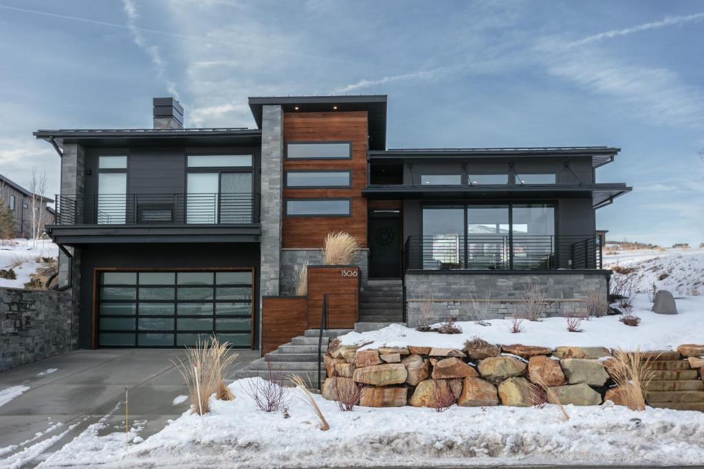 a house in the snow with a stone wall at 1506 W Orion Way - SkyRidge 6 BR Home with Hot Tub home in Keetley