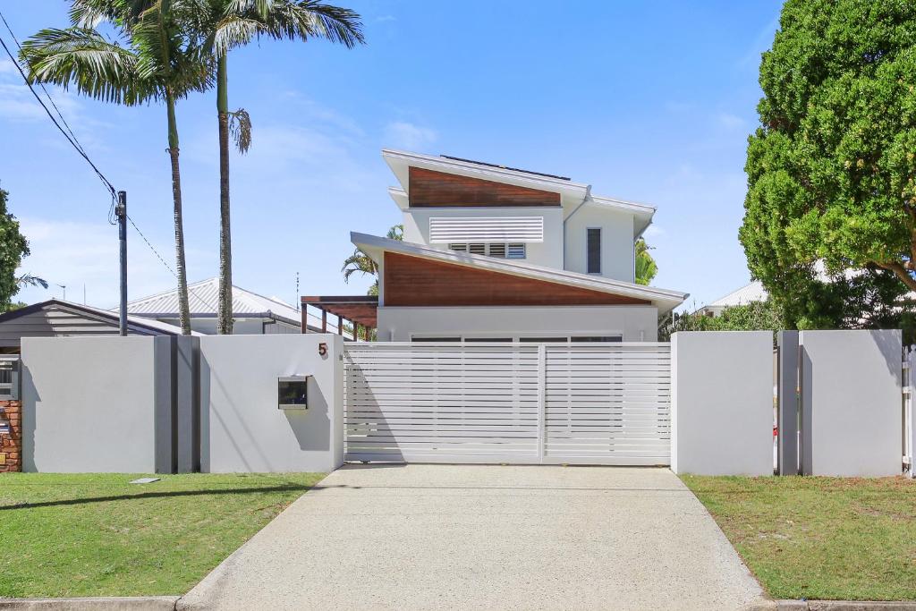 a house with a white fence and a driveway at Golden Beach Oasis - Sleeps 12 in Golden Beach