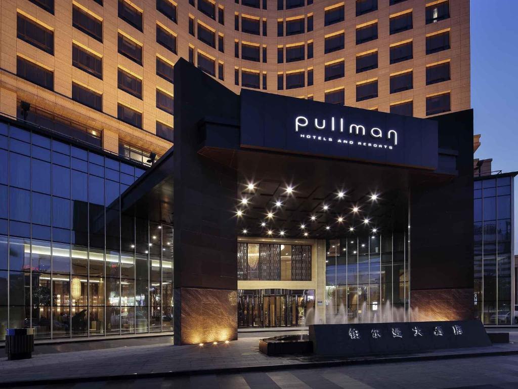 un bâtiment avec une enseigne sur la façade dans l'établissement Pullman Anshan Time Square, à Anshan