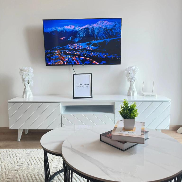 a living room with a table and a tv on the wall at Dream Nook - One Bedroom Apt in Tatu City in Tatu City