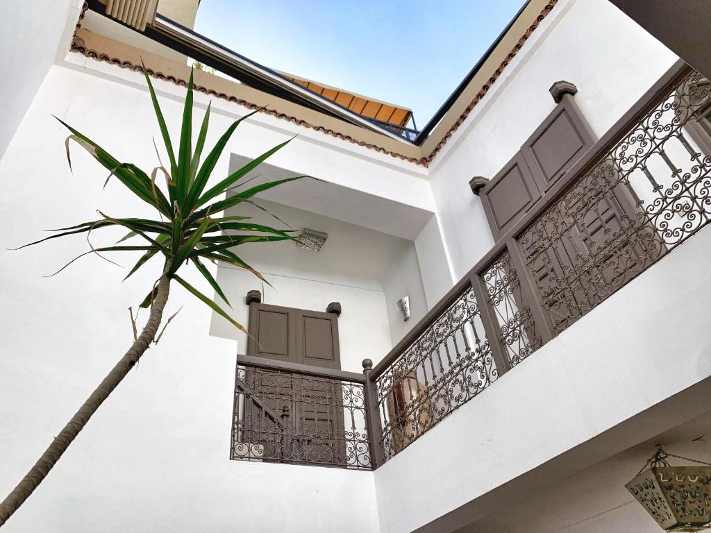 a white house with a palm tree in front of it at Top Riad 6 persons 5 minutes main square in Marrakech