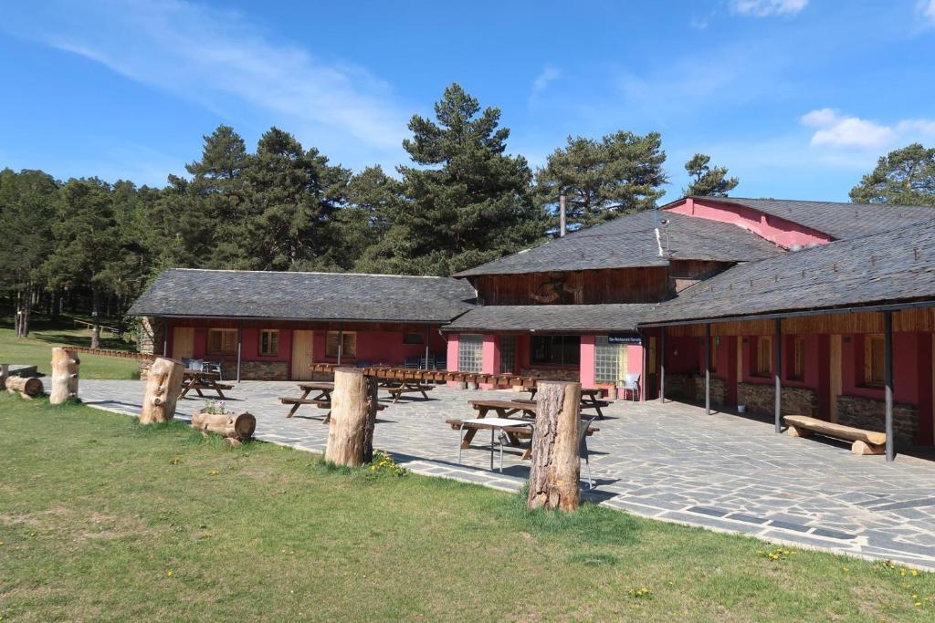 a group of picnic tables in front of a barn at Refugi La Basseta in Vall de Castellbò