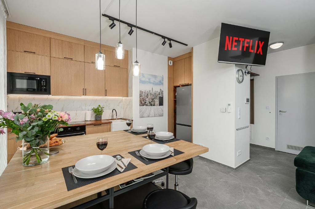 a kitchen with a wooden table with plates on it at Lumina Premium Apartments with view on center Warsaw in Warsaw