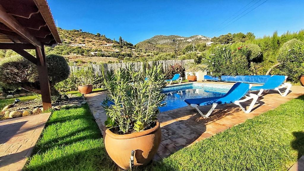 un patio trasero con piscina, sillas y mesa en Villa 72 by Villamya, en Madrigueras
