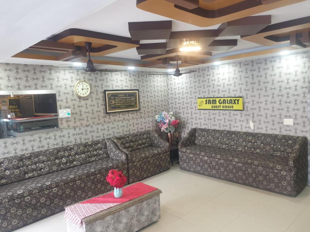 钦奈sam galaxy guest house的一间设有两张沙发和一张桌子的等候室