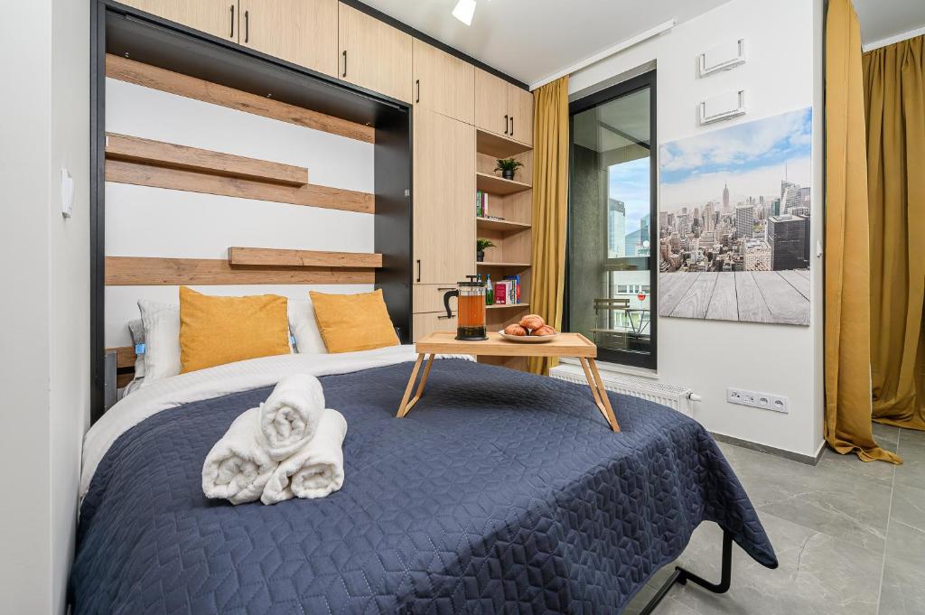ワルシャワにあるLumina Premium Apartments on 15th Floorのベッドルーム1室(テーブル付)