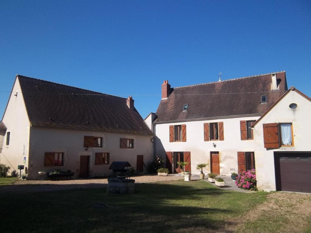 una casa blanca con techo negro y patio en Domaine d'Harlot, en Saint-Éloi