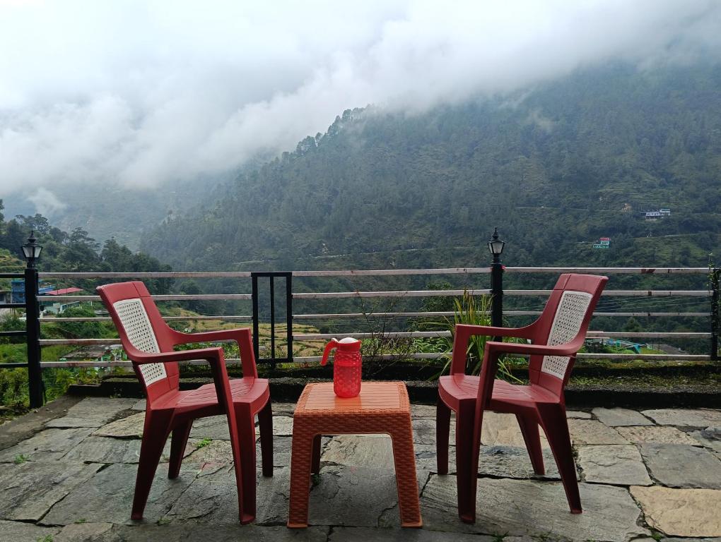 three chairs and a table with a view of a mountain at Global home stay in Sari