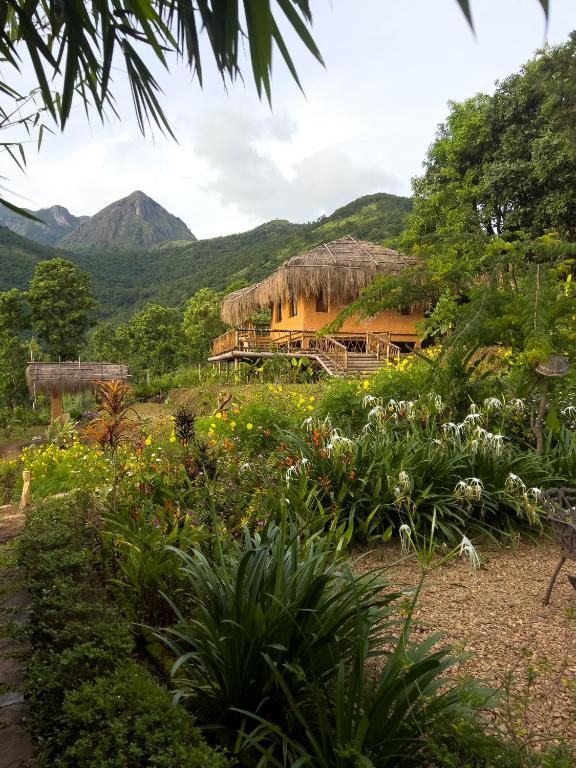 a resort with a garden and mountains in the background at The Mudhouse Marayoor in Munnar