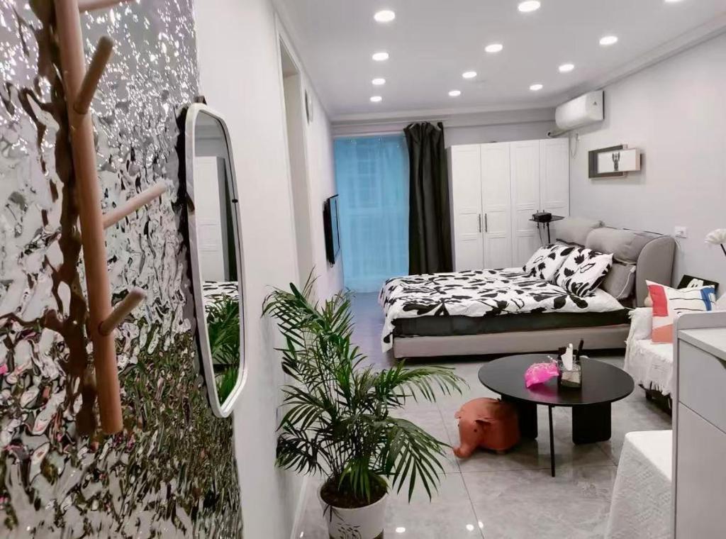 a living room with a bed and a couch at Aisen Apartment Huainan Wanda Plaza Near City Center in Huainan