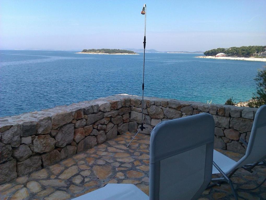 a stone wall with two chairs and a television at Apartment Sanja in Primošten
