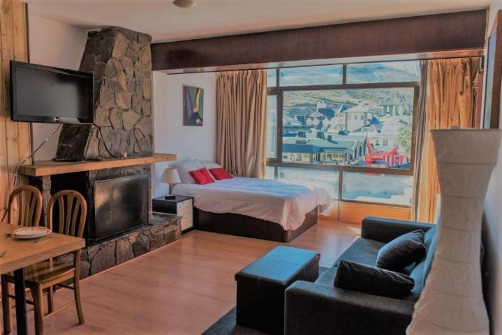 ein Hotelzimmer mit einem Bett und einem großen Fenster in der Unterkunft SKI & SNOW APARTMENTS - PLAZA DE PRADOLLANO - Junto a los Telecabinas by TODOSIERRANEVADA in Sierra Nevada