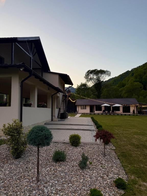 a house with a walkway in front of a yard at NOR Villa in Ciungetu