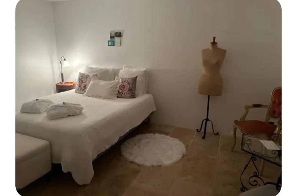 a bedroom with a white bed with a white rug at Maison 1838 