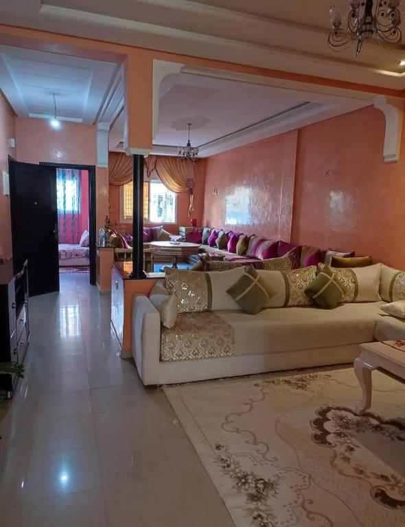a living room with a white couch in a room at Appartement de standing centre harhoura in Temara