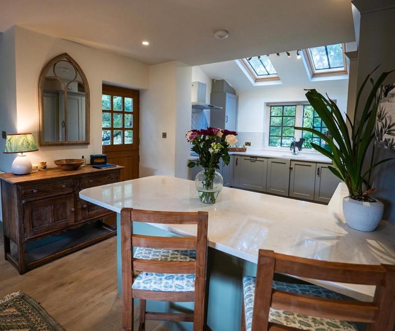 una cucina con un'isola con sedie e un tavolo con fiori di The little Hotel a Motcombe