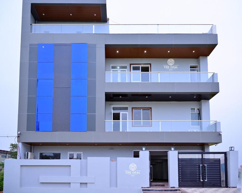 a tall white building with a balcony on it at The Opal Hotel in Greater Noida