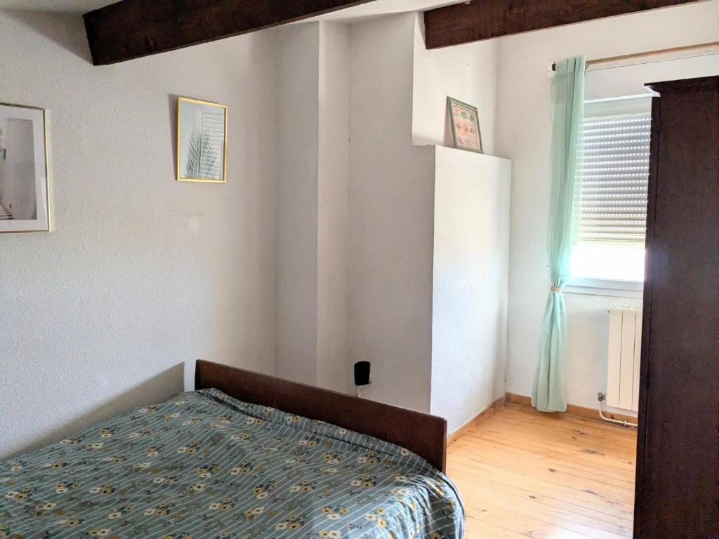 ナルボンヌにあるCharmante maison vue merのベッドと窓のある寝室