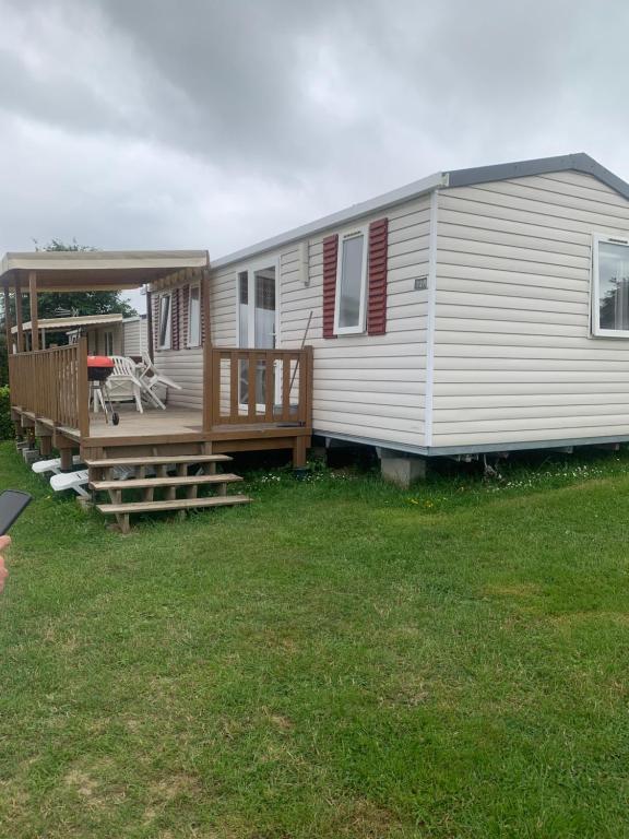 a mobile home with a porch and a deck at Mobil home ch ti in Litteau