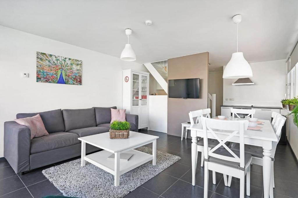 a living room with a couch and a table at Weststraat 22 - Ouddorp - Appartement Noord 3P in Ouddorp