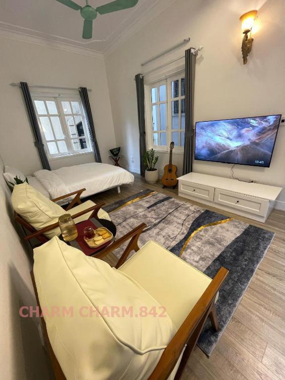 ein Wohnzimmer mit einem großen TV und einem Sofa in der Unterkunft CHARM CHARM - kimmy housing - 48 To Ngoc Van in Hanoi