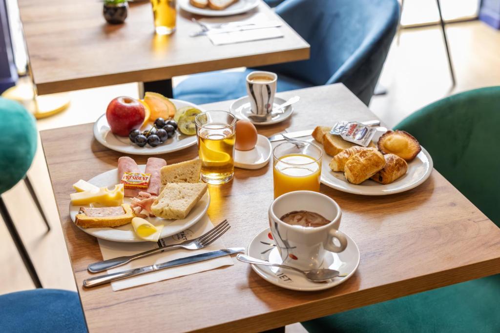 a table topped with plates of breakfast foods and drinks at Hotel Bristol Metz Centre Gare in Metz
