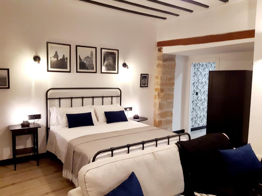 Un dormitorio con una cama grande con almohadas azules. en La Rúa 4, en Úbeda