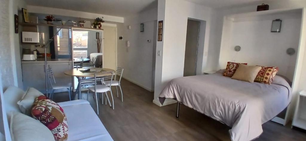 Un dormitorio con una cama y una mesa y una cocina. en Luz del Nahuel, en San Carlos de Bariloche