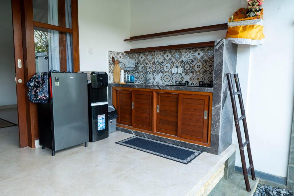 a kitchen with a stainless steel refrigerator and a stove at Good Karma House Ubud in Ubud