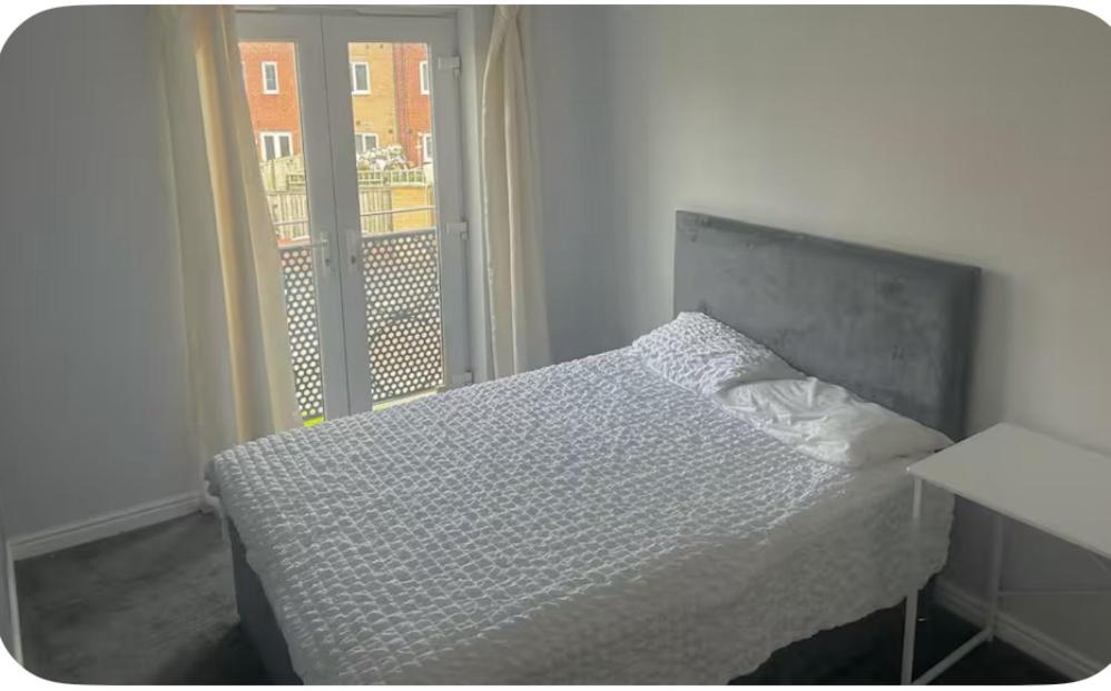 a bedroom with a bed and a large window at Shekinah glory in Stockton-on-Tees