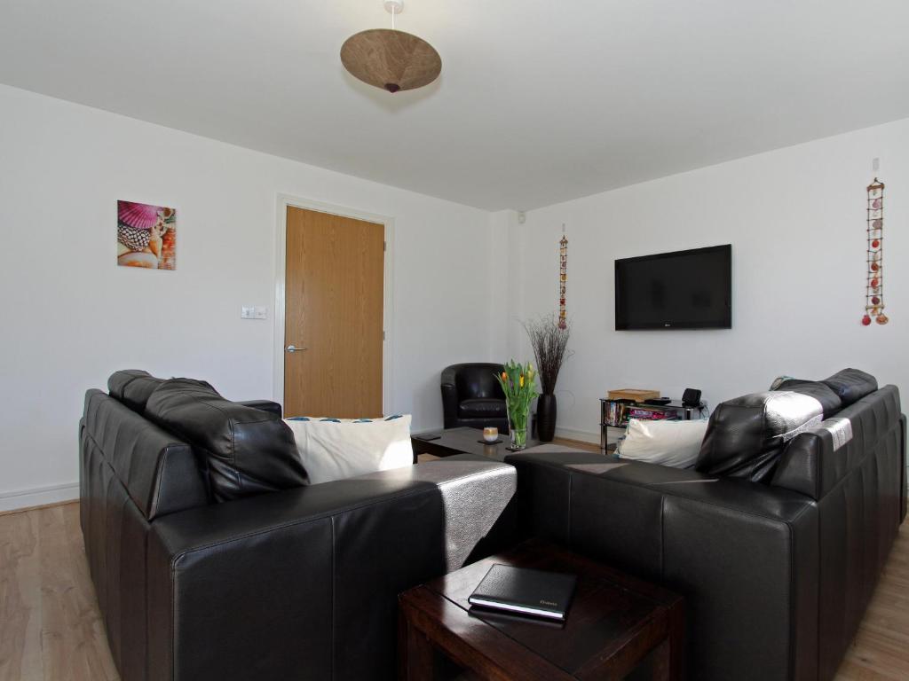 a living room with two leather couches and a table at 6 Jubilee Close in St Merryn